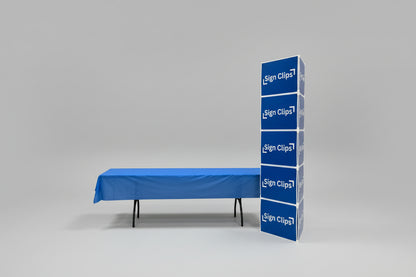 Sign Clip Floor Tower next to a table with a blue tablecloth. 