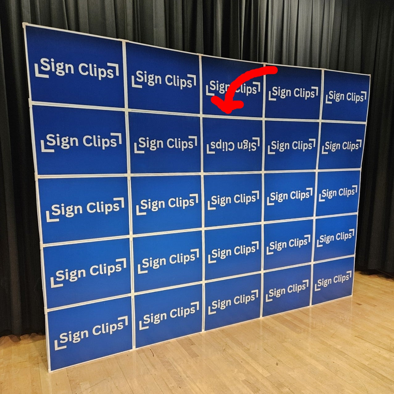 A large wall display made of multiple signs clipped together, featuring one intentional upside-down sign to demonstrate proper orientation.